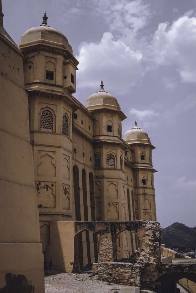 Explore the majestic sandstone architecture of Amber Fort in Jaipur under a vibrant sky.