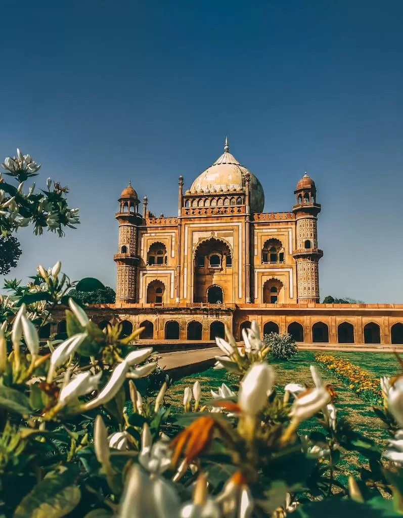 Majestic view of Safdarjung Tomb surrounded by gardens in New Delhi, India, under clear skies.