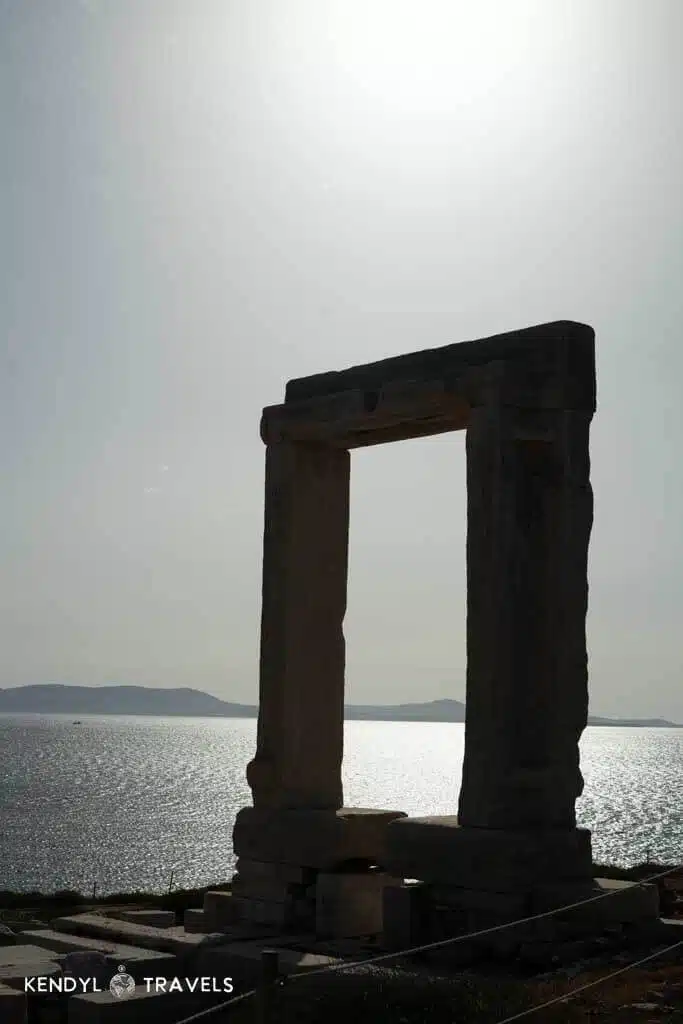 Silhouette of the iconic Portara, the Temple of Apollo’s marble gate, glowing against the Aegean Sea at sunset in Naxos.