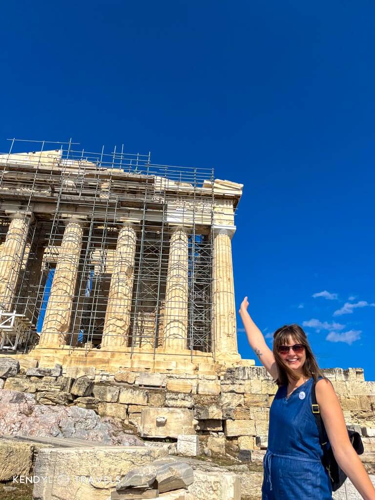 Tourist in sleeveless jumpsuit visiting the Parthenon in Athens, dressed comfortably for warm May weather.