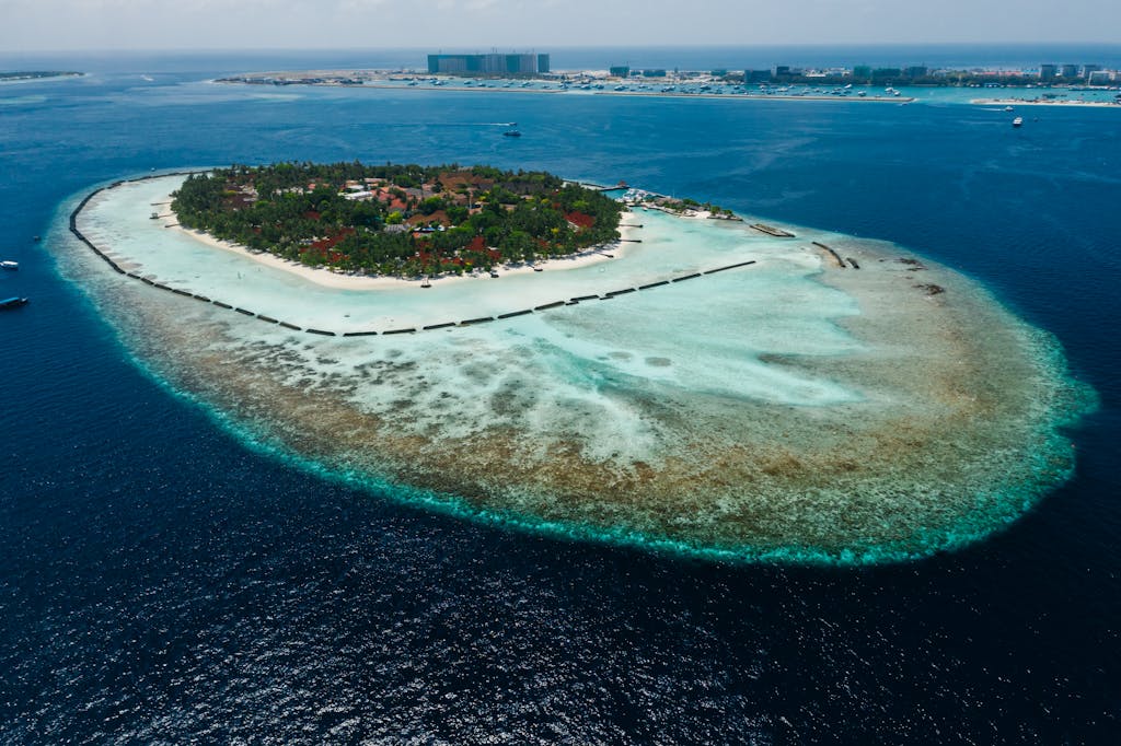 Breathtaking aerial shot of a lush tropical island surrounded by vibrant turquoise waters, ideal for vacation.